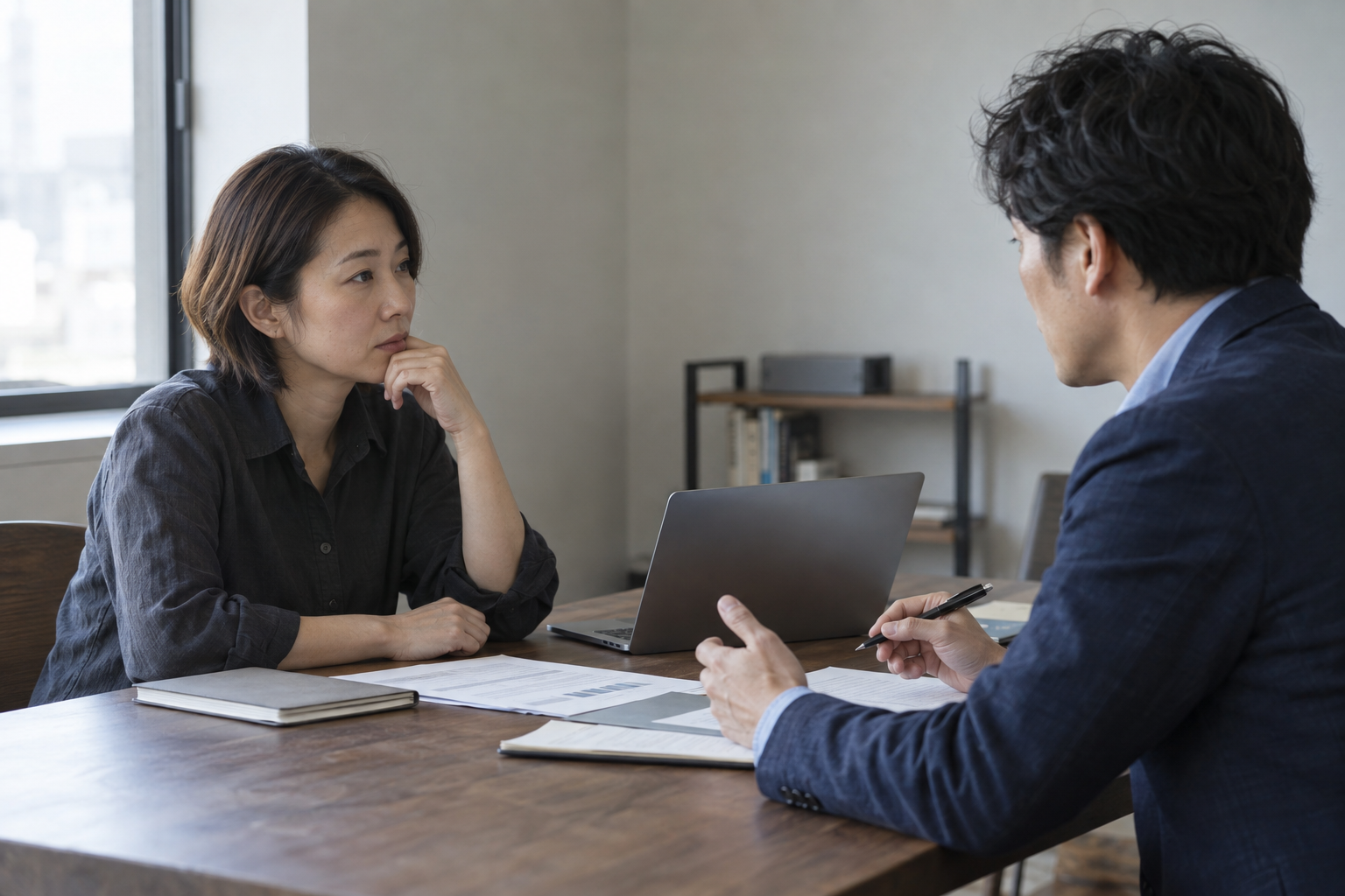 資料を囲み、相談者と仕事の進め方について話し合う二人のイメージ